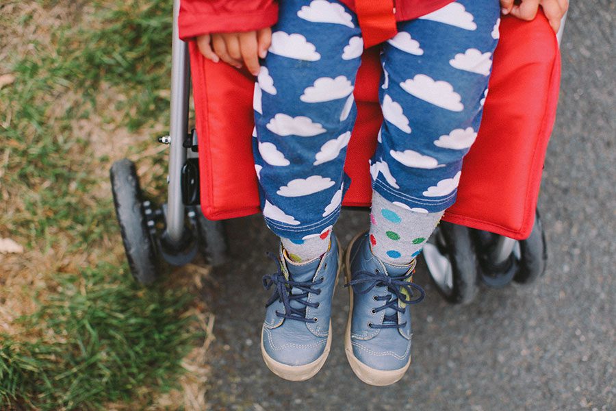 Ein Kinderbein in blauer Hose und blauen Schuhen mit weißen Wolken, eingefangen von einer Fotografin in einem Fotostudio Köln.