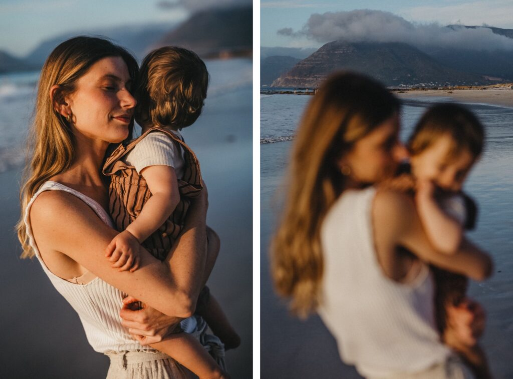 Eine Frau mit einem kleinen Kind am Strand bei Sonnenuntergang, Berge und Meer im Hintergrund. Das eine Bild ist scharf und die Frau lächelt, das andere ist leicht unscharf - aufgenommen von einem Familienfotografen für zeitlose Erinnerungen.